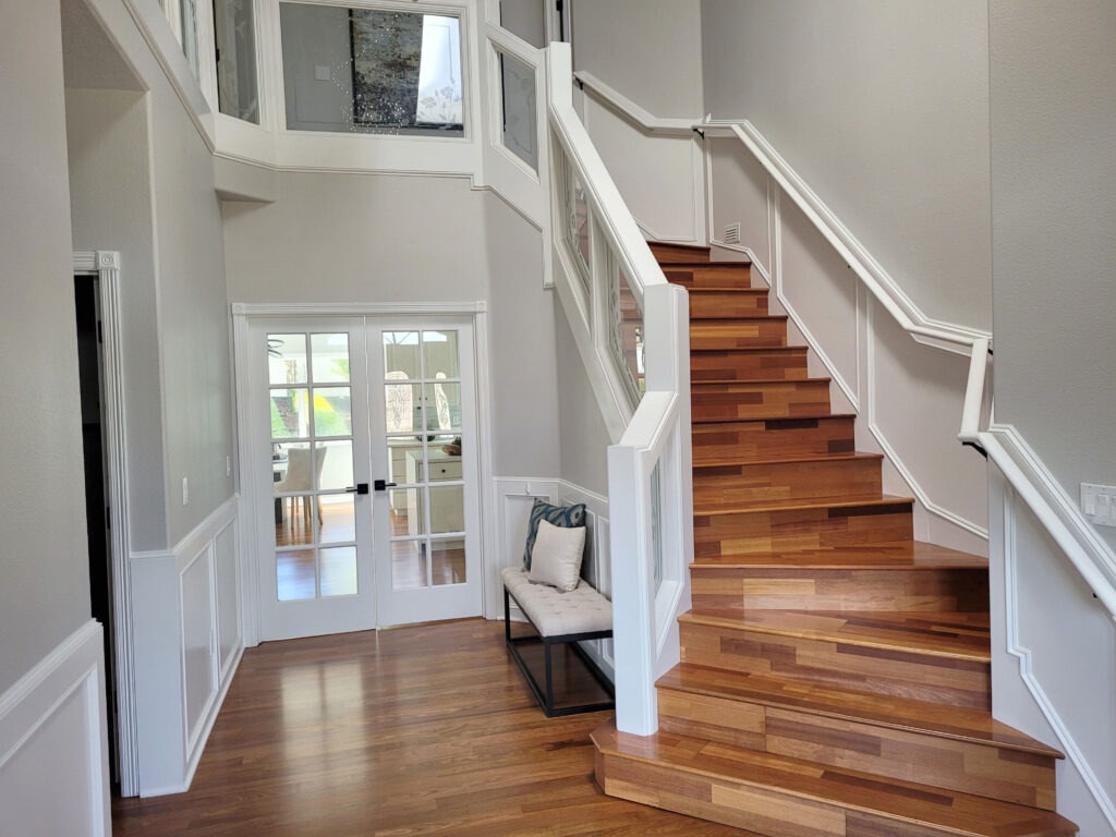 Freshly painted entryway with white trim and staircase railing
