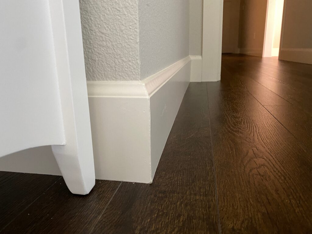 Close-up of freshly painted baseboard trim and wall