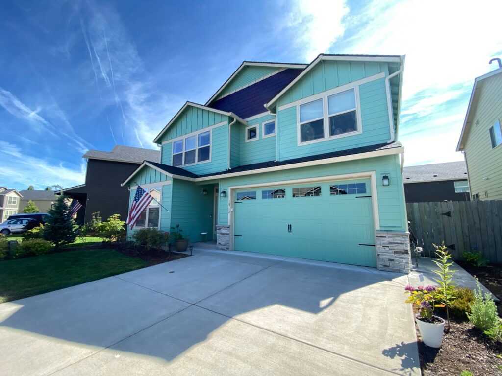 Two-story home with fresh teal exterior paint